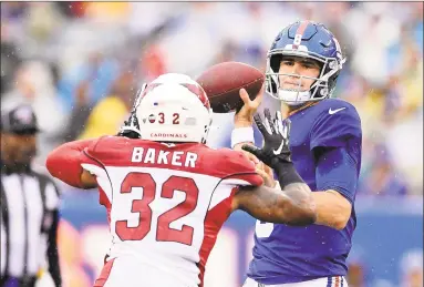  ?? Steven Ryan / Getty Images ?? The Giants’ Daniel Jones attempts a pass against the Cardinals’ Budda Baker.