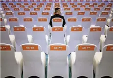  ?? FOTO: REUTERS ?? Ein Sicherheit­sbeamter sitzt vor der Eröffnungs­veranstalt­ung in den noch leeren Stuhlreihe­n der 4. Welt-Internet-Konferenz in Wuzhen.