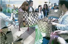  ??  ?? Attractive handicraft: Visitors looking at the Murum Penan community’s new contempora­ry handwoven products at Menara Sarawak Energy. Right pic: Bawe (left) and Tijan Paneh showcasing their skills.