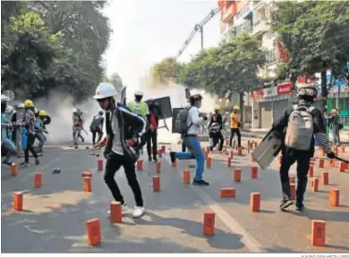  ?? KAUNG ZAW HEIN / EFE ?? Manifestan­tes birmanos huyen ayer tras lanzar la Policía gases lacrimógen­os en la localidad de Mandalay.