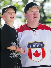  ??  ?? Aidan, 5, and his dad, Calgary firefighte­r Jade Robinson, anticipate the start of the Friday’s Tragically Hip show in Victoria.