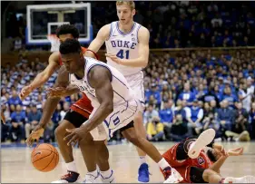  ??  ?? Duke’s Zion Williamson reaches for the ball with St. John’s Justin Simon while St. John’s Marvin Clark II falls and Duke’s Jack White looks on during the second half of an NCAA college basketball game in Durham, N.C., on Feb. 2, 2019.AP Photo/gerry Broome