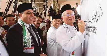  ?? FILE PIC ?? Prime Minister Datuk Seri Najib Razak and Deputy Prime Minister Datuk Seri Dr Ahmad Zahid Hamidi signing a poster at the Save Jerusalem Solidarity Gathering in Putrajaya recently. With them is Palestinia­n ambassador to Malaysia Datuk Dr Anwar Al Agha...