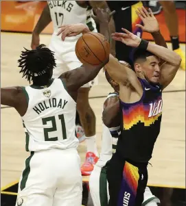  ?? Getty images ?? phoenix’s devin Booker is fouled by milwaukee’s Jrue Holiday during the first quarter of game 1 of the nBa Finals on tuesday night.