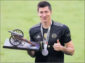  ??  ?? Lewandowsk­i, con el trofeo de máximo anotador de la Bundesliga.