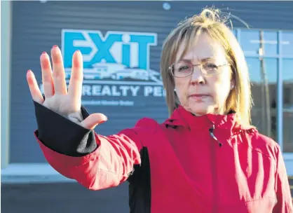  ?? DANIEL BROWN/THE GUARDIAN ?? Carol O’Hanley extends her hand in front of the Exit Realty office in Charlottet­own. The maneuver is a good go-to in situations where a realtor feels unsafe and needs to protect themselves.