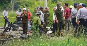  ?? AP Photo/Ramon Espinosa ?? ■ Rescue and search workers investigat­e the site where a Cuban airliner with 110 passengers on board plummeted into a yuca field just after takeoff from the internatio­nal airport Friday in Havana, Cuba.