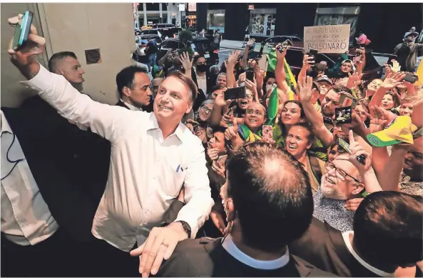  ?? FOTO: ALAN SANTOS/PALACIO PLANALTO/DPA ?? Der brasiliani­sche Präsident Jair Bolsonaro macht vor dem Barclay-Hotel in New York ein Selfie mit seinen Anhängern.