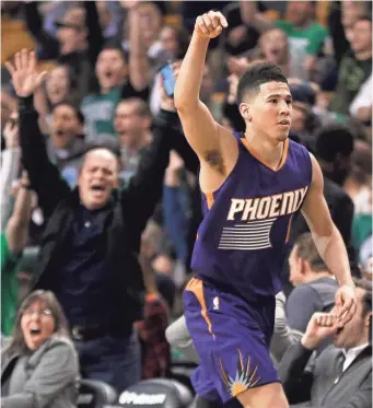  ?? ELISE AMENDOLA/AP ?? Suns guard Devin Booker gestures after scoring a basket as fans cheer him on during Friday’s game in Boston.