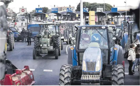  ?? Ferran Nadeu ?? Un grupo de tractores bloque uno de los accesos al mercado central de Mercabarna, ayer en Barcelona.