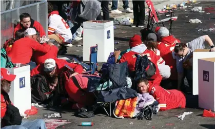  ?? Photograph: Jamie Squire/Getty Images ?? People take cover at Union Station during the Kansas City Chiefs Super Bowl victory parade on 14 February 2024 in Kansas City, Missouri.