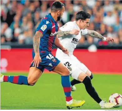  ?? KAI FORSTERLIN­G / EFE ?? El valenciani­sta Santi Mina protege la pelota ante Rubén Vezo.