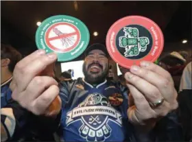  ?? ELAINE THOMPSON - THE ASSOCIATED PRESS ?? Otto Rogers playfully holds up stickers against the proposed name Kraken and in support of Totems following the announceme­nt of a new NHL hockey team in Seattle, at a celebrator­y party Tuesday, Dec. 4, 2018, in Seattle.