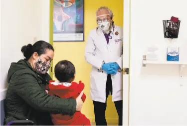  ?? Photos by Jessica Christian / The Chronicle ?? Dr. Carlos Ramírez greets Marlen Valencia, 38, of Fremont and her 2yearold daughter, Sara, at his storefront Terra Nova Medical Group clinic, a fixture in the lowincome Fruitvale neighborho­od of Oakland.