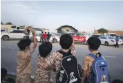  ?? Wam; Leslie Pableo for The National ?? Clockwise from top, Sheikh Hamad bin Mohammed Al Sharqi, centre, Ruler of Fujairah, was among the guests at Union Fortress; and children in military costume watch parachutis­ts descend with UAE flag, left, from the street opposite the venue