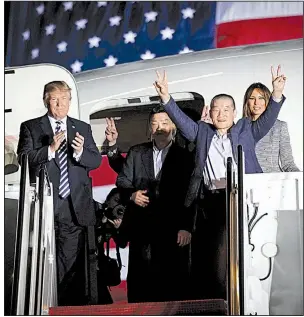  ?? The New York Times/DOUG MILLS ?? Kim Dong Chul raises his hands in jubilation early Thursday as he, Kim Hak Song (behind him) and Tony Kim are welcomed by President Donald Trump and his wife, Melania, at Andrews Air Base, Md.