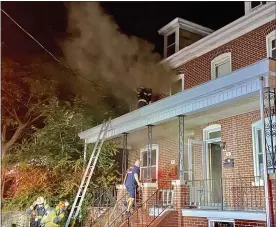  ?? PHOTOS BY EVAN BRANDT — MEDIANEWS GROUP ?? A Pottstown firefighte­r, breaks windows on the second floor of 7East Fifth St. early Monday morning to vent thick black smoke from the home.