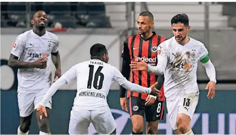  ??  ?? Borussias Lars Stindl (r) jubelt nach seinem Tor zum 3:3 mit Ibrahima Traoré (2.v.l.) und Marcus Thuram (l). Frankfurts Djibril Sow trauert.