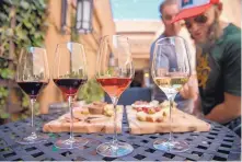  ??  ?? Max McCullen, left, and Matt Rogers, both from Los Angeles, sample wines and food at the new Hervé Wine Bar in Santa Fe on Monday.