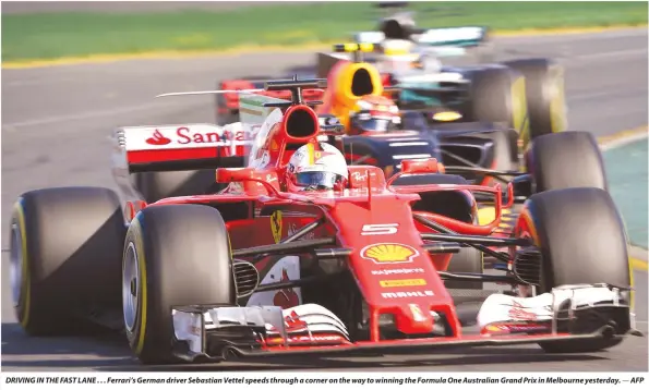  ?? — AFP ?? DRIVING IN THE FAST LANE . . . Ferrari’s German driver Sebastian Vettel speeds through a corner on the way to winning the Formula One Australian Grand Prix in Melbourne yesterday.