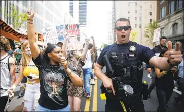  ?? Mike Simons Tulsa World ?? A POLICE officer works near a Black Lives Matter event June 20 in Tulsa, Okla. The relationsh­ip between police and Black Tulsans has improved over the years, but many in the Black community still fear officers.