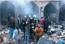  ?? Photo: Getty ?? Members of the Syrian Civil Defence search for survivors after the airstrike in the rebel-held village of Harem.