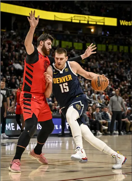  ?? AARON ONTIVEROZ — THE DENVER POST ?? Denver’s Nikola Jokic drives on Jusuf Nurkic of the Portland Trail Blazers during the first quarter at Ball Arena on Tuesday night. Jokic had another triple-double on the night.