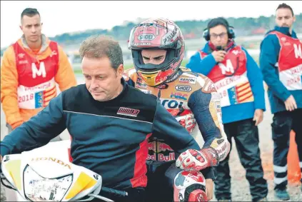  ?? FOTO: EFE ?? Emili Alzamora lleva en el scooter a Marc Márquez hasta el camión. El piloto de Cervera pasará por el quirófano a primeros de diciembre