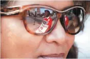  ?? AP PHOTO ?? Michael Grant, a parent of a Chicago public school student, is reflected Monday in the glasses of teacher Yasman Vaughn as a handful of teachers picket outside Shoop Elementary School in Chicago.
