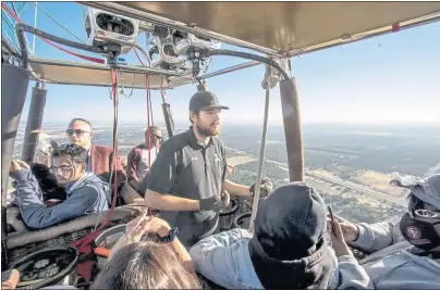  ?? PHOTOS BY KARL MONDON — STAFF PHOTOGRAPH­ER ?? Commercial balloon pilot Jake Molner takes 19 customers on a Balloons Above the Valley flight over Winters, one valley over from Napa’s Wine Country.