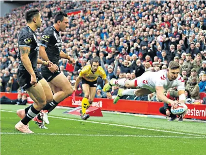  ??  ?? Touch of class: Tommy Makinson dives over the line to score one of his hat-trick of tries for England in the second Test win over New Zealand