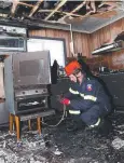  ??  ?? DESTROYED: Fire investigat­or Jason Mather examines the kitchen.