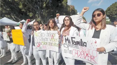  ??  ?? Durante la protesta, los estudiante­s portaron batas blancas manchadas de rojo con los nombres de los tres jóvenes que fueron asesinados, entre ellos, dos colombiano­s que estaban de intercambi­o en la ciudad poblana.
