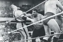  ?? CHARLIE BENNETT/THE ASSOCIATED PRESS ?? The Chicago Bears’ William Perry, right, lands a punch on Jim “The Anvil” Neidhart during the Over-The-Top-Rope battle royal at WrestleMan­ia 2 in Rosemont, Ill., in 1986.