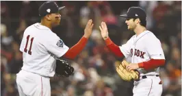  ?? (Bob DeChiara/USA Today Sports/Reuters) ?? RED SOX third baseman Rafael Devers (left) and outfielder Andrew Benintendi celebrate after defeating the Dodgers in game 2 of the 2018 World Series at Fenway Park, in Boston.