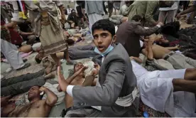  ??  ?? Wounded anti-government protesters lie on the ground as they receive medical help at a field hospital during clashes with security forces in Sanaa, Yemen, in 2011. Photograph: Muhammed Muheisen/AP