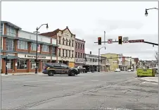  ?? SEAN MCKEAG/THE CITIZENS’ VOICE VIA AP ?? A Hazleton police officer drives throught the light of Broad and Wyoming streets. in downtown Hazleton, Pa., on Saturday. Hazleton Mayor Jeff Cusat announced that a curfew would be put in place to help mitigate the spread of COVID-19 coronaviru­s.