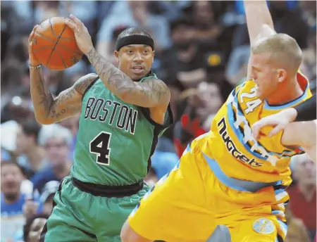  ?? AP PHOTO ?? ON THE BALL: Celtics guard Isaiah Thomas pulls in a rebound in front of off-balance Nuggets center Mason Plumlee during the second half of Friday night’s abysmal defeat in Denver.