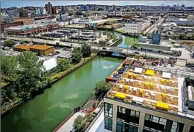  ?? BEBETO MATTHEWS/AP ?? A rooftop lounge of a new Brooklyn, N.Y., apartment building overlooks the Gowanus Canal, a smelly waterway choked with raw sewage and industrial wastes.