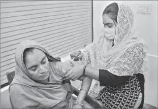  ??  ?? HYDERABAD
A lady health worker administer­ing anti-corona vaccine to a lady citizen at Anti Corona Vaccinatio­n Center at KKF Hospital. -APP
