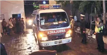  ?? (AP FOTO) ?? EXECUTED PRISONERS. Police officers watch as a convoy of ambulances carrying the bodies of drug trafficker­s drive past by at Wijaya Pura port upon arrival from the prison island of Nusakamban­gan in Cilacap, Java, Indonesia.