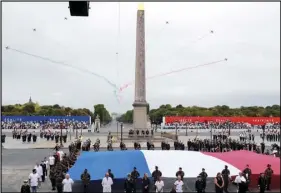  ?? ASSOCIATED PRESS ?? Members of medical staff pose with the French flag as they take part in the annual Bastille Day military ceremony on the Place de la Concorde in Paris, Tuesday.