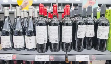  ?? RYAN REMIORZ / THE CANADIAN PRESS ?? Bottles of wine at a Quebec liquor store are turned backwards Wednesday as part of a union tactic to protest lagging contract negotiatio­ns at the province’s liquor outlets.