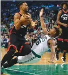  ?? The Associated Press ?? Toronto Raptor Norman Powell runs over Boston Celtic Marcus Smart on his way to the basket during a 101-94 Toronto win in Boston on Friday.