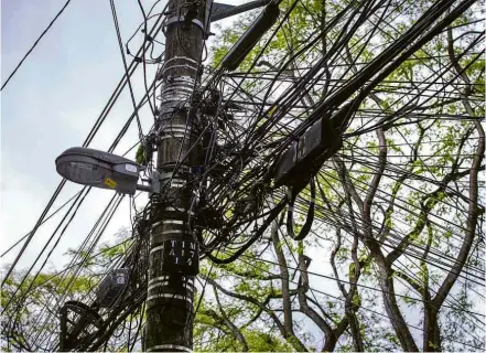  ??  ?? Poste com emaranhado de fios na Lapa, zona oeste; concession­ária mira 2.100 postes