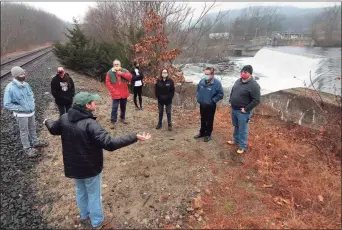  ??  ?? Ken Zak, here with arms raised and below, leads a tour of the Kinneytown Dam along the Naugatuck River in Seymour on Dec. 12.