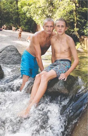  ?? Picture: BRENDAN RADKE ?? COOLING OFF: Michael Blanchford keeps a close eye on his 13-year-old son Harvey as they dodge the heat at Josephine Falls.