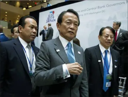  ?? JOSE LUIS MAGANA — THE ASSOCIATED PRESS ?? Japan’s Finance Minister Taro Aso, center, leaves Friday after the group photo of the G20 Finance Minister and Central Bank Governors at the World Bank/IMF Spring Meetings in Washington.