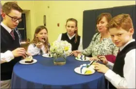  ?? EVAN BRANDT — DIGITAL FIRST MEDIA ?? After posing for all those photos, students from St. Aloysius Parish School were finally able to enjoy some cake.