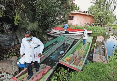  ??  ?? UN MÉDICO se baja de un bote en su camino para recolectar muestras para detectar Covid-19 en una casa en Xochimilco